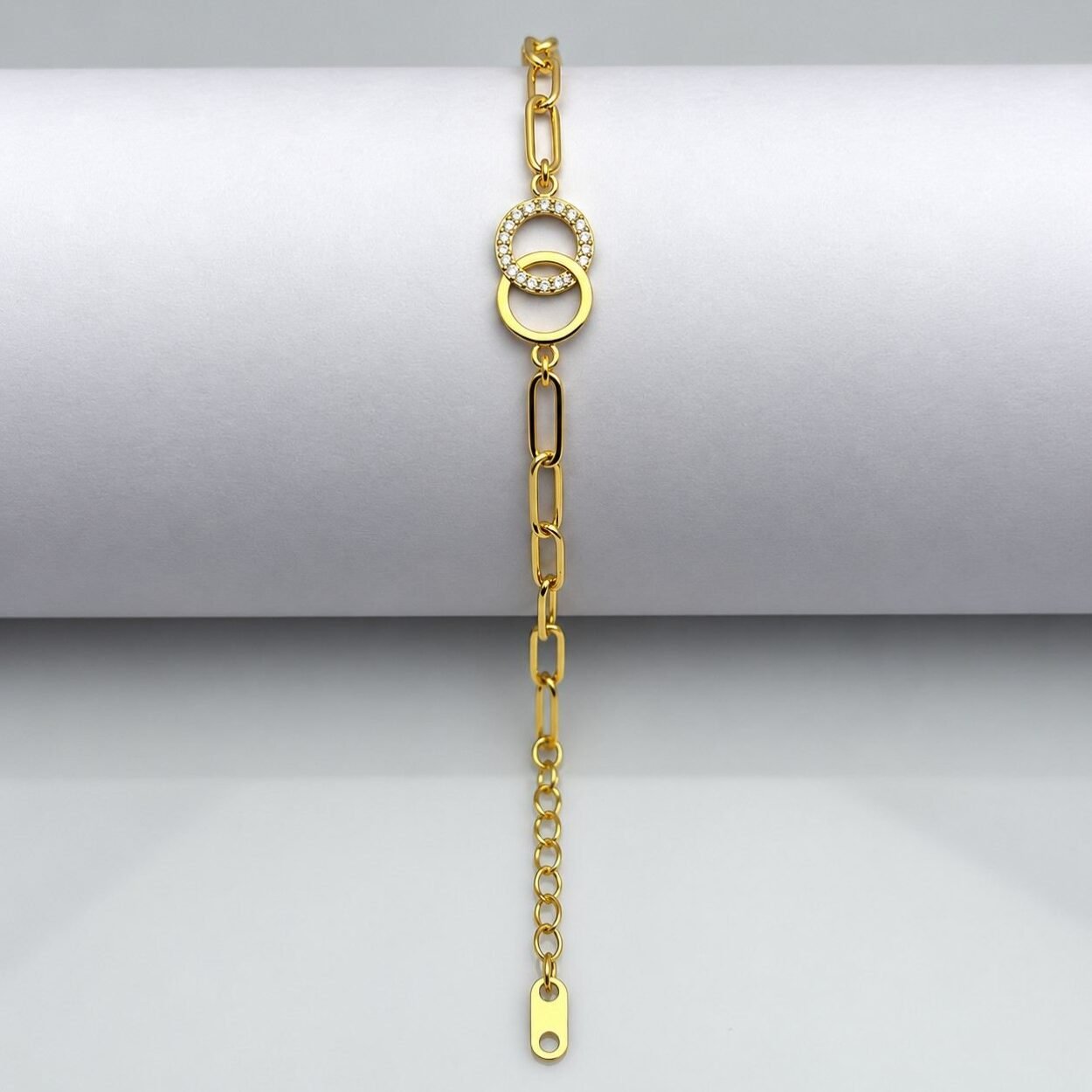 Gold chain bracelet with interlocking circle charms and crystal accents on white background.