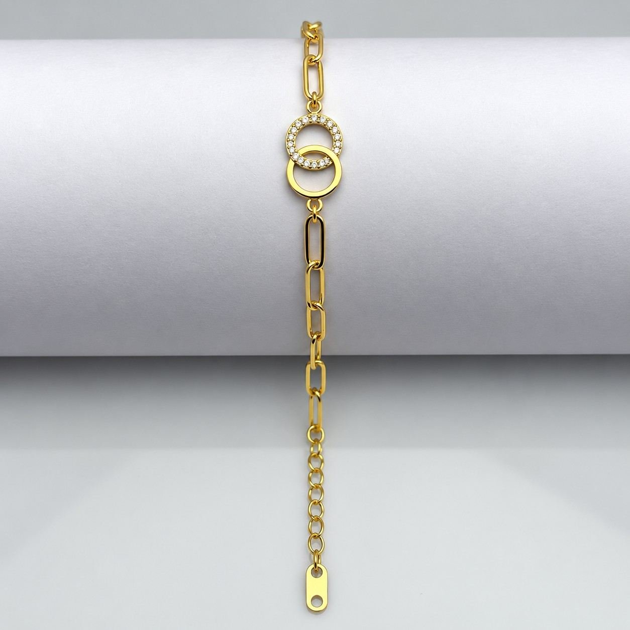 Gold chain bracelet with interlocking circle charms and crystal accents on white background.