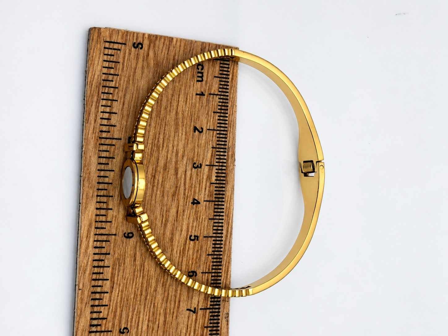 Elegant Roman numeral bangle with mother-of-pearl center detail.