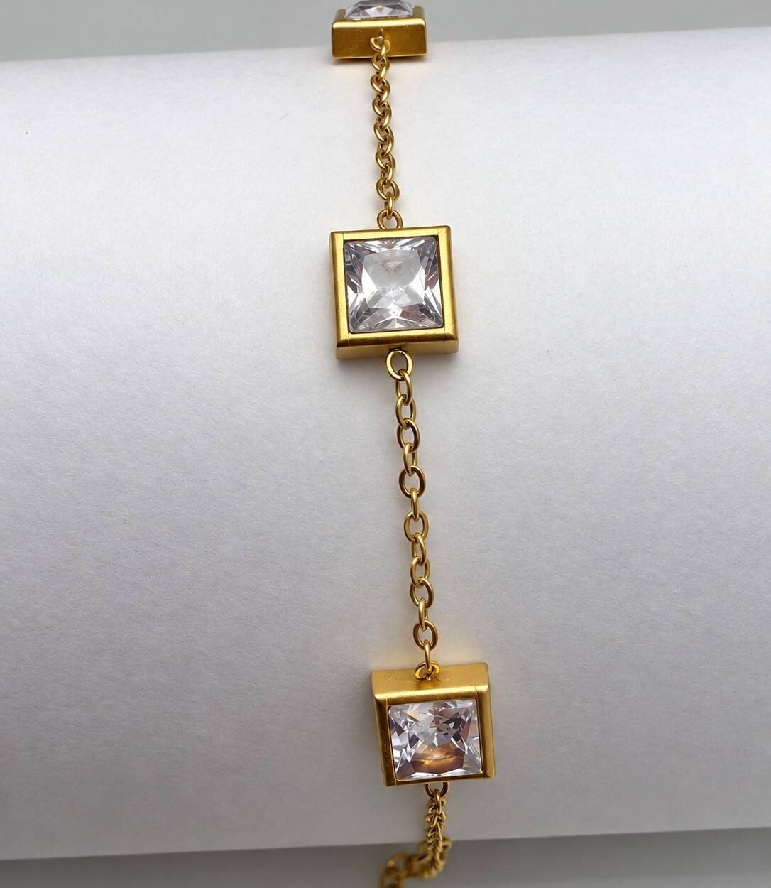 A refined gold-tone bracelet featuring brilliant square-cut crystal stones that add subtle glamour to both casual and formal outfits.